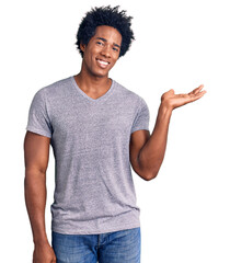 Handsome african american man with afro hair wearing casual clothes smiling cheerful presenting and...
