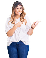 Young caucasian woman wearing casual clothes pointing aside worried and nervous with both hands,...