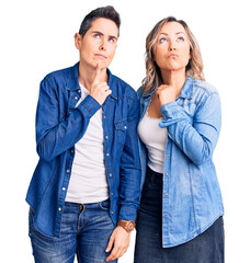 Couple of women wearing casual clothes thinking concentrated about doubt with finger on chin and looking up wondering