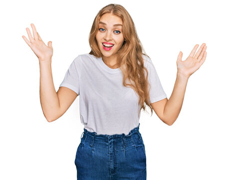 Young caucasian girl wearing casual white t shirt celebrating victory with happy smile and winner expression with raised hands