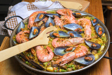 Close-up of shrimp and mussel paella in a pan with a wooden spatula, typical Spanish cuisine, Majorca, Balearic Islands, Spain