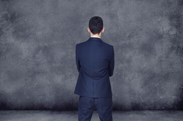 Businessman, thinking and decision with choice for ideas, selection or pick on a gray studio background. Rear view of man or employee in wonder, thought or choose for career ambition on mockup space