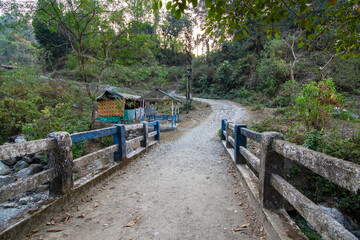 A village bridge way to mountains with lots of green trees on the way to Buxa Fort.