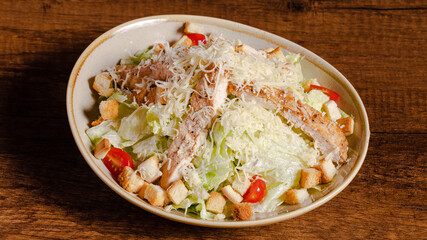 Chicken caesar salad bowl on wooden background