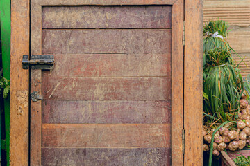 old dirty wooden board door with vintage lock for storage on vegetable market