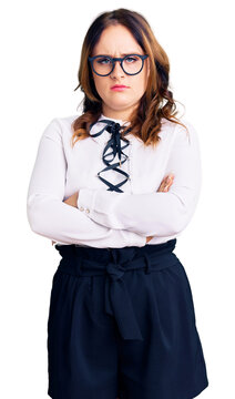 Young beautiful caucasian woman wearing business shirt and glasses skeptic and nervous, disapproving expression on face with crossed arms. negative person.