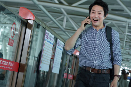 Subway platform of middle-aged man make a phone call