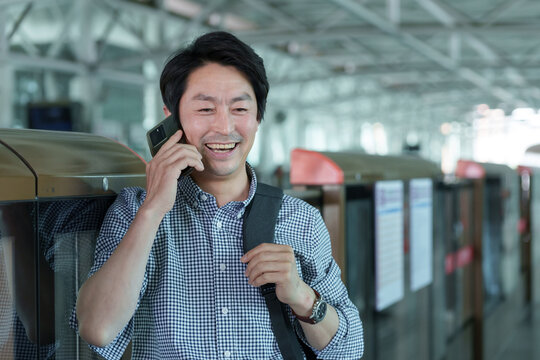 Subway platform of middle-aged man make a phone call