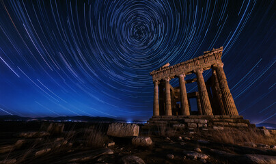 A long-exposure photo of the night sky above an ancient Greek temple. Star trails in a night sky, long exposure style , star motion - obrazy, fototapety, plakaty