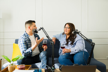 Latin podcast co-hosts having fun recording an episode drinking wine