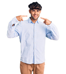 Young hispanic man wearing casual shirt smiling cheerful showing and pointing with fingers teeth and mouth. dental health concept.
