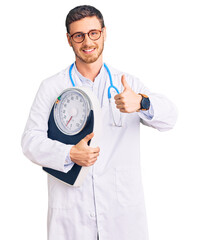 Handsome young man with bear as nutritionist doctor holding weighing machine smiling happy and...