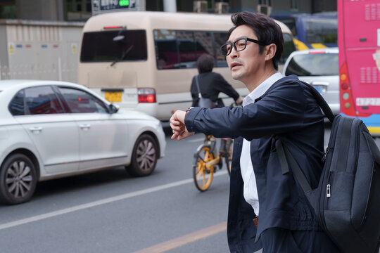 Middle-aged men road waiting for a taxi