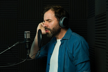 Male vocal artist recording a song in studio