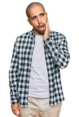 Fototapeta na wymiar Hispanic adult man wearing casual clothes touching mouth with hand with painful expression because of toothache or dental illness on teeth. dentist