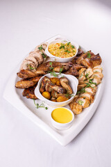 Assorted roasted meats, colorful vegetables, and golden potatoes garnished