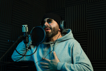Passionate male vocalist recording in studio
