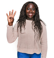 Young african woman wearing wool winter sweater showing and pointing up with fingers number four while smiling confident and happy.