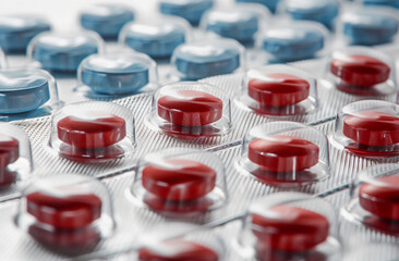Close-up of red and blue pills in blister pack. Medical treatment and pharmaceutical product...