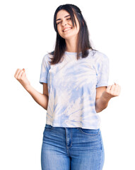 Young beautiful girl wearing casual t shirt very happy and excited doing winner gesture with arms raised, smiling and screaming for success. celebration concept.