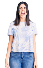 Obraz premium Young beautiful girl wearing casual t shirt angry and mad screaming frustrated and furious, shouting with anger. rage and aggressive concept.