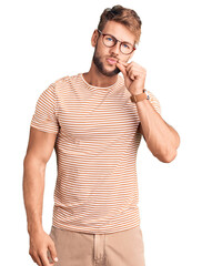 Young caucasian man wearing casual clothes and glasses mouth and lips shut as zip with fingers....