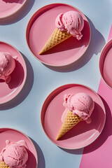 top view of Ice cream in pink plates on blue background.  Summer minimal concept.