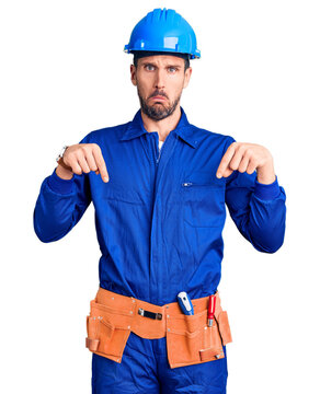 Young handsome man wearing worker uniform and hardhat depressed and worry for distress, crying angry and afraid. sad expression.