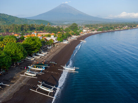 Fischer laden am Morgen, am schwarzen Strand von Amed, Fische aus ihren Auslegerboote, Berg Agung im Hintergrund, Amed Bali, Indonesien