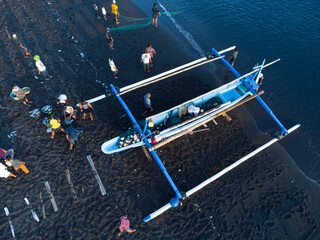 Fischer laden am Morgen, am schwarzen Strand von Amed, Fische aus ihren Auslegerboote, Berg Agung im Hintergrund, Amed Bali, Indonesien - obrazy, fototapety, plakaty