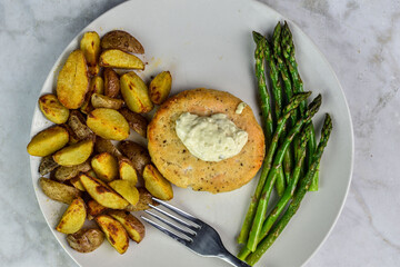salmon burger with sayteed asparagus and potato wedges,
