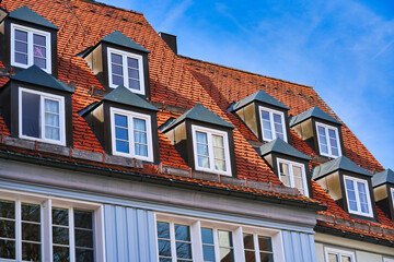 Fototapeta na wymiar typical dormer windows of a German town on a pitched roof and orange tiles