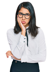 Beautiful asian young woman wearing business shirt and glasses thinking looking tired and bored with depression problems with crossed arms.