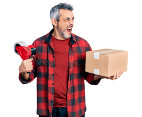 Middle age hispanic with grey hair holding packing tape and cardboard box angry and mad screaming frustrated and furious, shouting with anger. rage and aggressive concept.