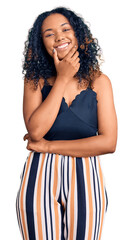 Young african american woman wearing casual clothes looking confident at the camera smiling with crossed arms and hand raised on chin. thinking positive.