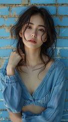 Portrait of Asian attractive woman against background of blue brick wall