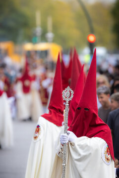 Nazareno, bearer in a procession of the easter week in Seville, andalusia, Spain. 2024 Semana Santa. Red hood, procession of 23.03.2024