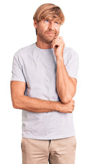 Handsome caucasian man with beard wearing casual tshirt serious face thinking about question with...
