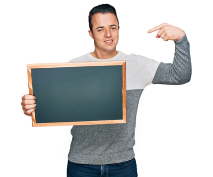 Handsome young man holding blackboard pointing finger to one self smiling happy and proud - Powered by Adobe