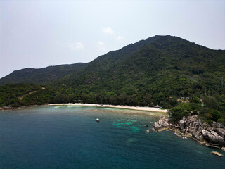 Aerial drone view small Koh Ma island, Ko Phangan Thailand. Exotic coast panoramic landscape, Mae Haad beach, summer day. Sandy path between corals. Vivid seascape, mountain coconut palms from above.