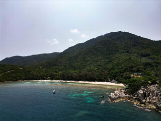 Aerial drone view small Koh Ma island, Ko Phangan Thailand. Exotic coast panoramic landscape, Mae Haad beach, summer day. Sandy path between corals. Vivid seascape, mountain coconut palms from above.