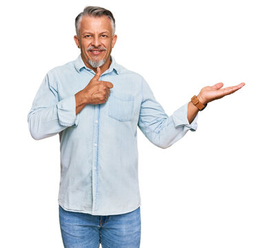 Middle age grey-haired man wearing casual clothes showing palm hand and doing ok gesture with thumbs up, smiling happy and cheerful