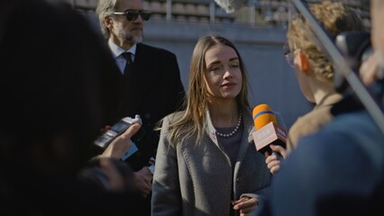 Two organization representative answer press questions and give interview on a soccer stadium....