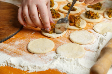 Jewish women's hands lay out the poppy seed filling for sweet gomentash for the holiday of Purim
