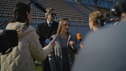 Two organization representative answer press questions and give interview on football stadium....