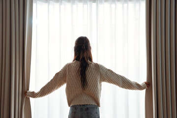 Smiling Asian woman opening curtains at morning, Hands pulling window curtain