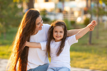 Happy mother having fun with her daughter outdoor - Family and love concept. Portrait of mother and...