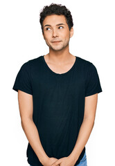 Young handsome man wearing casual black t shirt smiling looking to the side and staring away thinking.