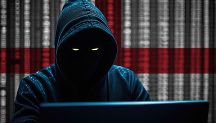 Hacker in a dark hoodie sitting in front of a monitors with England flag and background cyber security concept