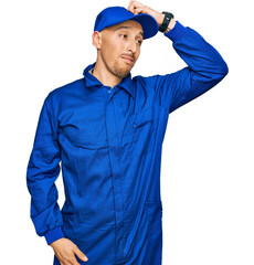 Bald man with beard wearing builder jumpsuit uniform smiling confident touching hair with hand up gesture, posing attractive and fashionable